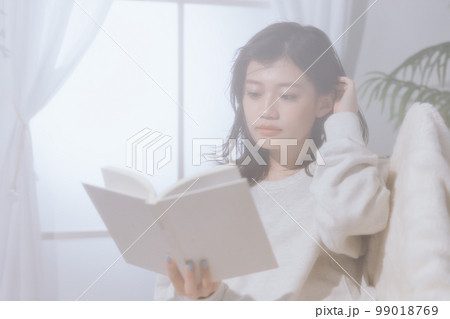 ソファーに寝転がる若い女性の写真 99018769