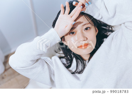 ソファーに寝転がる若い女性の写真 ソファーに寝転がる若い女性の写真 99018783