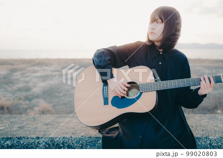 ギターを弾いている若い女性の写真 ギターを弾いている若い女性の写真 99020803