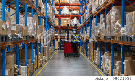 物流倉庫内でフォークリストで作業する作業者 99021953