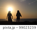 夕日をバックに女性のシルエット 99023239