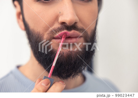 Transgender person focused on coloring his lips 99023447