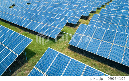 Aerial shot of solar panels farm on the green field. Renewable alternative green energy concept. Aerial shot of solar panels farm on the green field. Renewable alternative green energy concept. 99024193