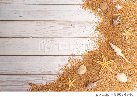 Sand seashells background. Summer time concept with sea shells and starfish on wooden background and sand Sand seashells background. Summer time concept with sea shells and starfish on wooden background and sand 99024946