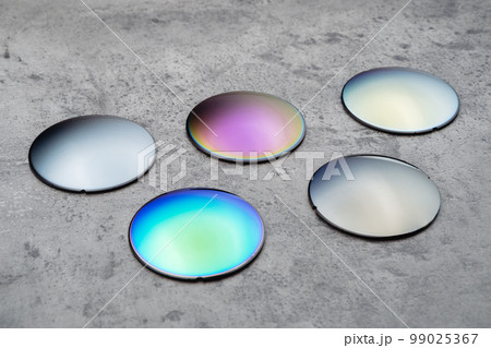 Different optical lenses on table in opical workshop Different optical lenses on table in opical workshop 99025367
