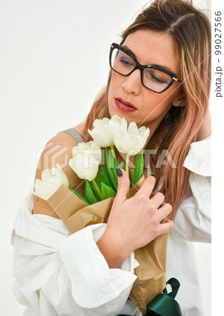 Bouquet of white tulips in a female hand on a white background. Bouquet of white tulips in a female hand on a white background. 99027566