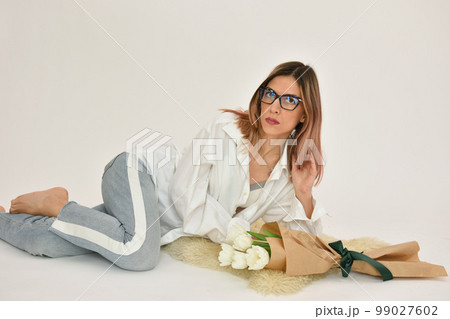 Bouquet of white tulips in a female hand on a white background. Bouquet of white tulips in a female hand on a white background. 99027602