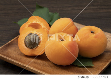 木皿に乗せた輪切りにしたあんず 99027704