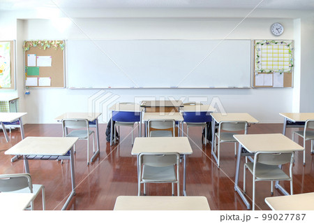 教壇と並んだ生徒の机とイス。教室、学校イメージの背景素材 99027787