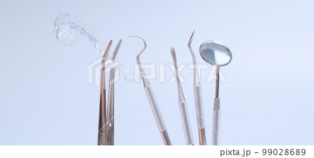 Dental tools and model of teeth on a blue background. Dental care concept. Invisible braces 99028689