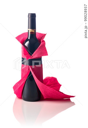 Bottle of red wine wrapped in crepe paper isolated on a white background. Bottle of red wine wrapped in crepe paper isolated on a white background. 99028937