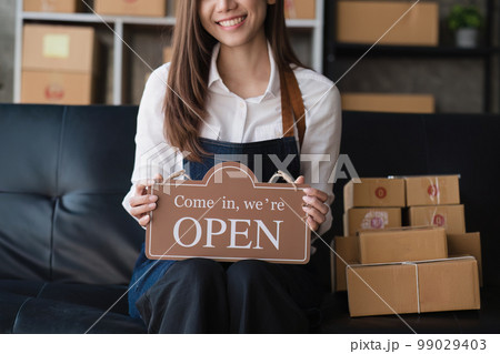 Beautiful Businesswoman start small business. A woman works from home delivering parcels online. Entrepreneurs, SME delivery concept Beautiful Businesswoman start small business. A woman works from home delivering parcels online. Entrepreneurs, SME delivery concept 99029403