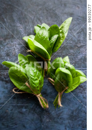 Bunches of green spinach, green vegetables, rustic style, healthy lifestyle, proper nutrition. Top view Bunches of green spinach, green vegetables, rustic style, healthy lifestyle, proper nutrition. Top view 99030277