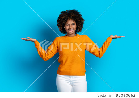 happy young black lady holding something invisible on both hands happy young black lady holding something invisible on both hands 99030662