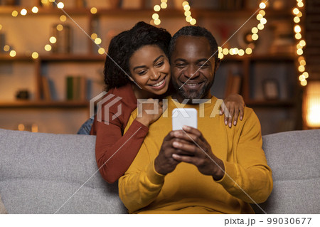 Loving african american spouses taking photo on phone Loving african american spouses taking photo on phone 99030677