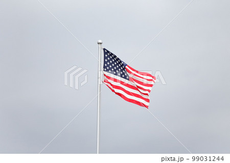 風に吹かれるアメリカの国旗 99031244