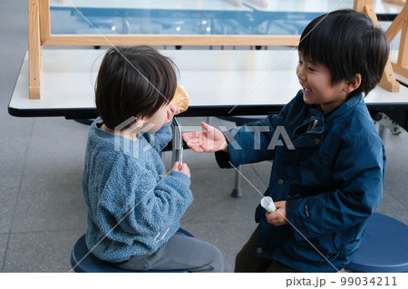 ソフトクリームを食べる子供達 99034211