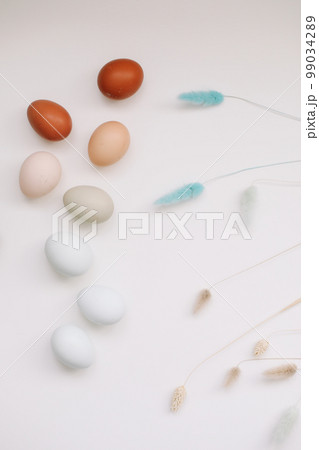 Happy Easter concept. Fresh chicken eggs of natural shades and colors on a white background Happy Easter concept. Fresh chicken eggs of natural shades and colors on a white background 99034289