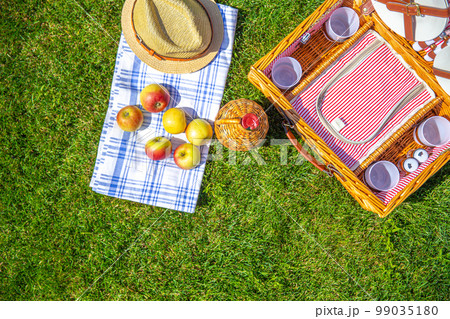 Green lawn with pic nic concept. Set of glasses and plates 99035180