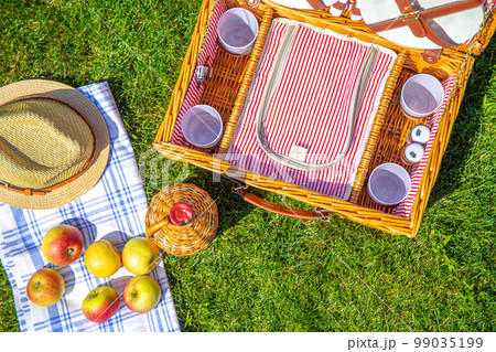 View from above on Picnic basket on green sunny lawn in the park 99035199