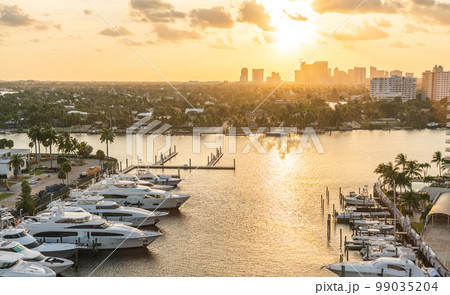 Luxury yacht parked on a canal with the sun coming down at Fort Lauderdale. Port of Fort Lauderdale with Sunset at the marina area Luxury yacht parked on a canal with the sun coming down at Fort Lauderdale. Port of Fort Lauderdale with Sunset at the marina area 99035204