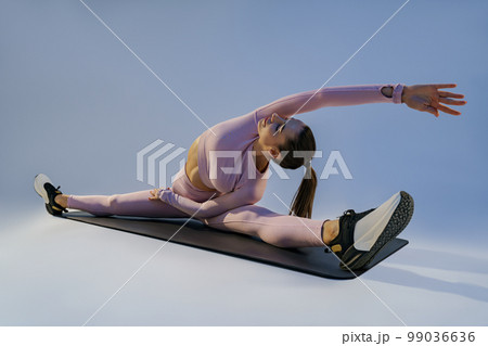 Flexible woman doing stretching exercises on yoga mat on studio background. Healthy lifestyle 99036636