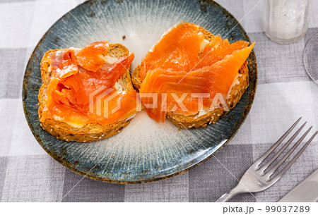 Two sandwiches with white bread butter and smoked salmon 99037289