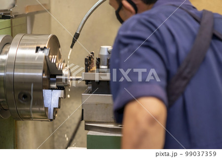 The machine operator working with lathe machine. 99037359