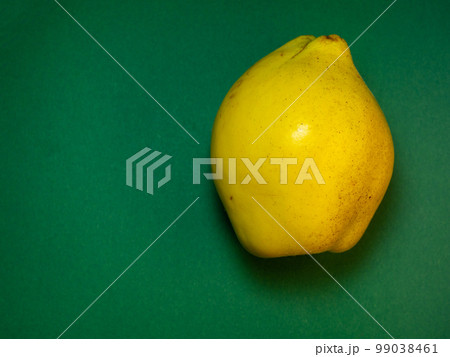 Juicy quince. Fruit on a green background. Ripe useful product. Juicy quince. Fruit on a green background. Ripe useful product. 99038461