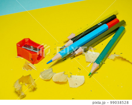 School supplies. Pencil sharpening. Pencil sharpener . Multicolored pencils.   The process of preparing for work. Creative mess 99038528