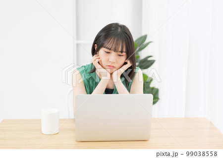 パソコンを見ながら悩んでいる若い女性 99038558