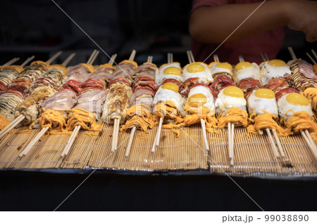 Street food , Japanese Pizza or Okonomiyaki roll on top egg ,cheese and bacan with chopsticks ready to eat. Street food , Japanese Pizza or Okonomiyaki roll on top egg ,cheese and bacan with chopsticks ready to eat. 99038890