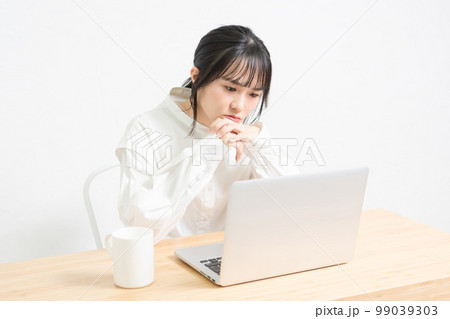 ノートパソコンを使いながら悩んでいる女性 99039303