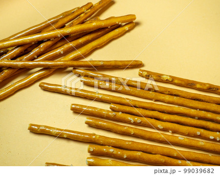 Salted sticks. Confectionery on the table. Salty baked goods. Snack for beer. Dough product on a beige background. 99039682
