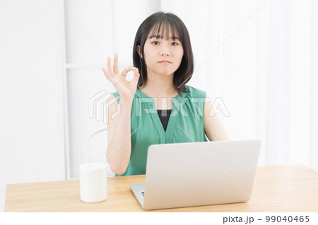 PCの前でOKのサインをする若い女性 99040465