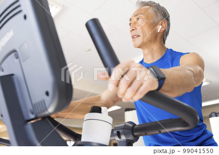 スポーツジムでエアロバイクに乗る中高年男性 スポーツジムでエアロバイクに乗る中高年男性 99041550
