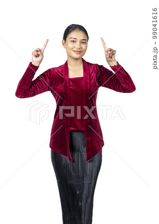 Asian girl wearing red kebaya traditional clothes pointing at something 99041616