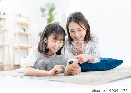 寝そべる親子 スマホ 寝そべる親子 スマホ 99044172