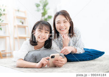 寝そべる親子 スマホ 寝そべる親子 スマホ 99044184