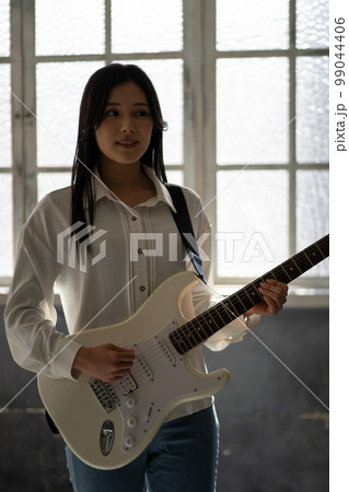 若い女性ポートレート（逆光、エレキギター） 99044406