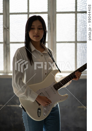若い女性ポートレート（逆光、エレキギター） 99044408