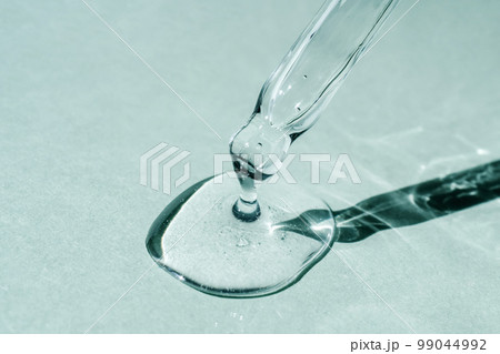 A drop of cosmetic oil falls from the pipette 99044992