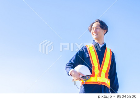 青空の下ヘルメットを持った若いガードマン 青空の下ヘルメットを持った若いガードマン 99045800