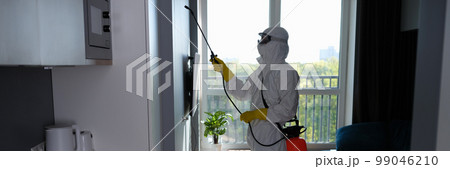 Worker in protective suit cleans room from cockroaches and rats with spray gun 99046210