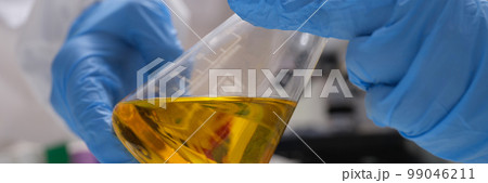 Hand drawn scientist holding laboratory glassware with golden oil liquid in chemistry lab Hand drawn scientist holding laboratory glassware with golden oil liquid in chemistry lab 99046211