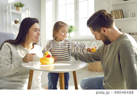 Little girl is having fun at home playing with toys with her loving mom and dad. Little girl is having fun at home playing with toys with her loving mom and dad. 99046488
