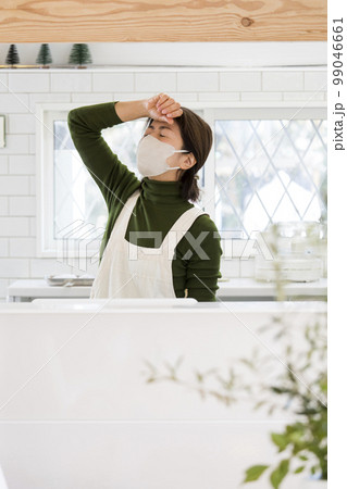 体調不良の日本人主婦、風邪、マスク姿で家事 99046661