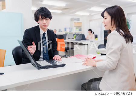 窓口で対応する男性スタッフ 窓口で対応する男性スタッフ 99046723