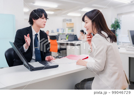 窓口で対応する男性スタッフ 窓口で対応する男性スタッフ 99046729