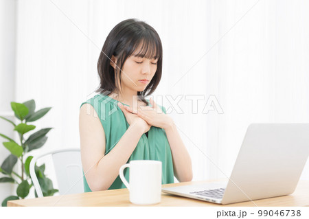PCの前で胸に手を当てている若い女性 99046738